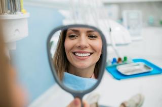 SmileFund | Patient looking at new smile after using SmileFund