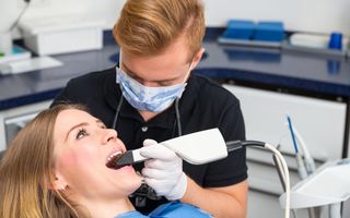 Dentist using CEREC to scan the mouth of a patient